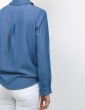 patron de couture Chemise Liseron dans une viscose bleu jean de chez Cousette porté avec un jean blanc, vue 3/4 dos