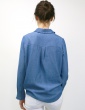 patron de couture Chemise Liseron dans une viscose bleu jean de chez Cousette porté avec un jean blanc, vue de dos