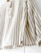 patron de couture Blouse Petites Choses dans une viscose beige rayée, focus sur le bijou de vêtement en bois cousu au bas de la blouse