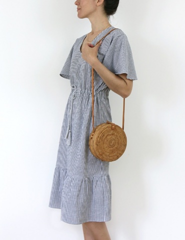 Robe Helios version mi-longue et petites manches, en coton rayé Les Coupons de Saint Pierre, vue 3/4 avec sac en paille rond