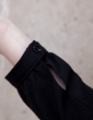 patron de couture Robe Be Pretty pour femme enceinte réalisée dans un élégant tissu noir, gros plan sur le poignet