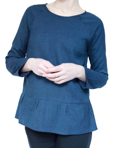 Blouse Stockholm réalisée dans un lainage fin bleu, version avec basque à plis creux au bas du top, vue de face