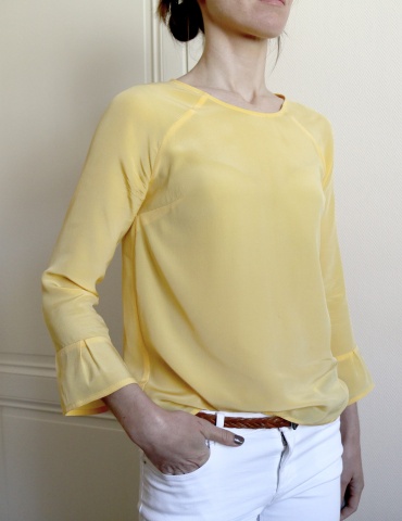 Blouse Stockholm réalisée dans une soie jaune, vue de 3/4 main dans la poche