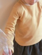 patron de couture Sweat Scammit réalisé dans un molleton moutarde, empiècements épaule dans le même tissu surpiqué, vue de face en contre plongé