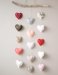 patron de couture Mobile composé de 15 cœurs dans des tons chauds, accroché au mur, photo gros plan